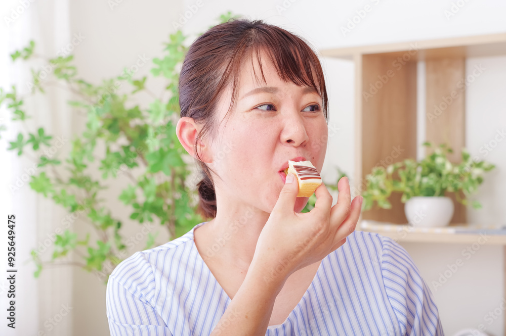 お菓子を食べてリラックスするミドル女性 お菓子を食べてリラックスするミドル女性