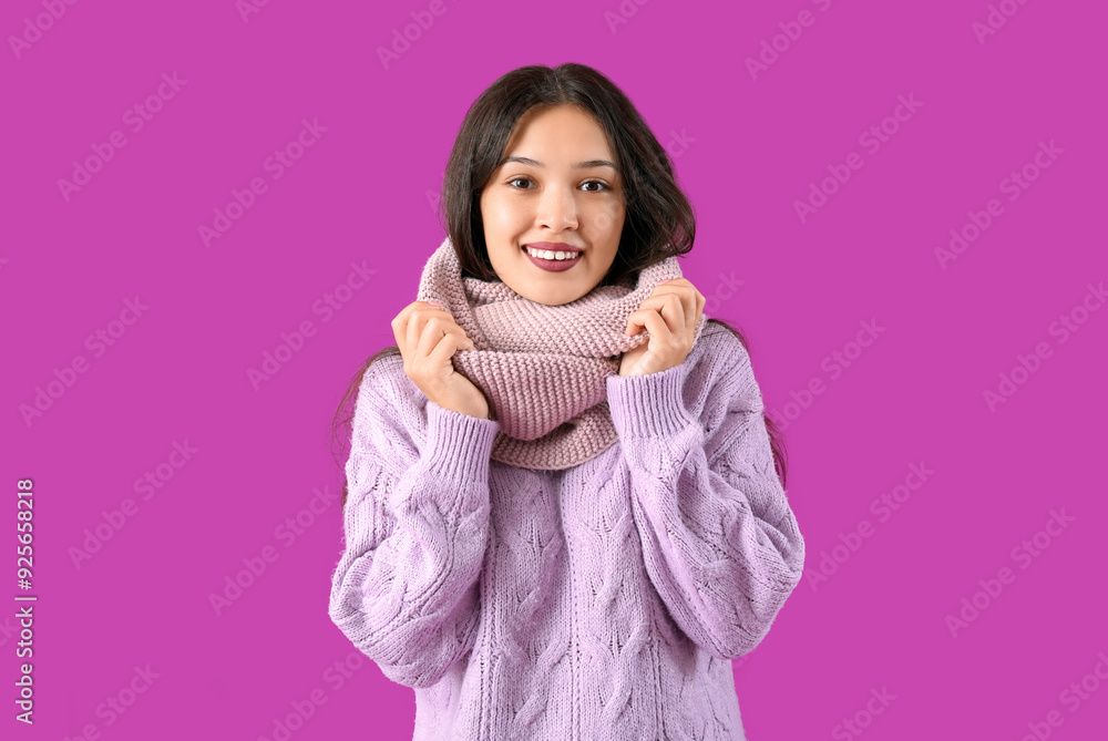 Beautiful young Asian woman in warm scarf on purple background Beautiful young Asian woman in warm scarf on purple background