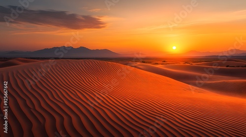 Sunset over desert dunes, golden sand, deep orange sky, soft shadows, distant mountains, serene landscape, warm colors, soft light, tranquil atmosphere, minimalist composition, expansive view.