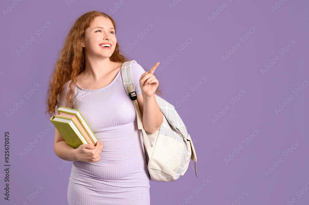 Happy female student with backpack and books pointing at something on lilac background Happy female student with backpack and books pointing at something on lilac background