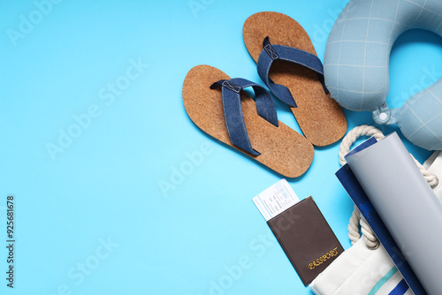 Travel pillow, ticket, wallet, map, bag and flip-flops on blue background photo