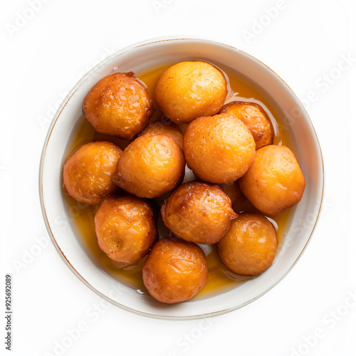 a bowl of doughnuts with syrup on a white surface photo