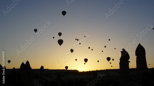 Nevşehir, Cappadocia - November 2 2022: Hot air balloons soaring in the sky during sunrise, creating a peaceful scene against the vibrant sunrise sky.