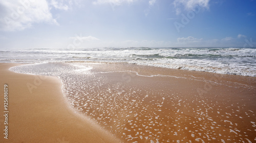 Seascape showing crashing waves from rough surf rolling onto the wet sand following days of bad weather along the coastline on the Sunshine Coast, Kawana, Queensland, Australia photo