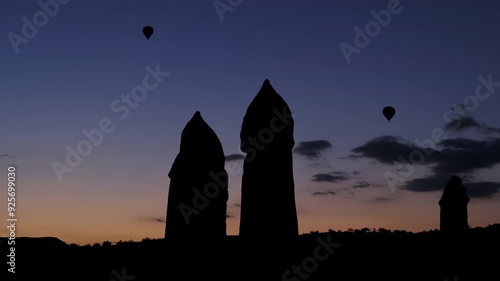 Nevşehir, Cappadocia - November 2 2022: Hot air balloons soaring in the sky during sunrise, creating a peaceful scene against the vibrant sunrise sky.