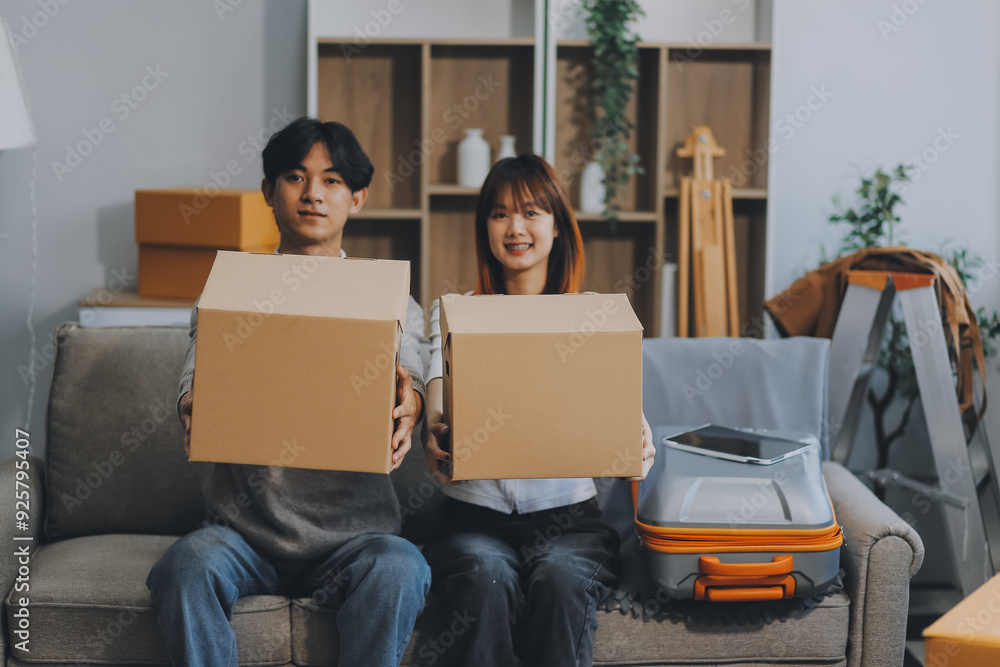 Young Asian couple relocating to a new house, joyfully packing and unpacking belongings. Expertise in moving, packing, togetherness, and creating a new home together. Young Asian couple relocating to a new house, joyfully packing and unpacking belongings. Expertise in moving, packing, togetherness, and creating a new home together.