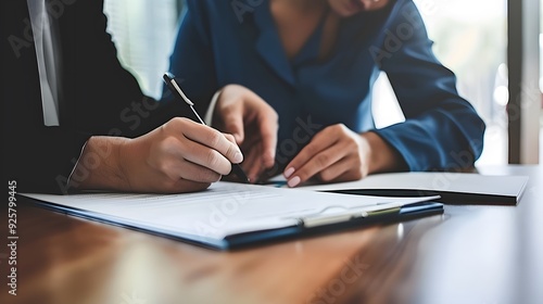 Serious Couple Signing Contract in Contemporary Office: Focused and Professional in a Well-Lit, Organized Workspace photo