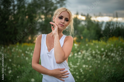 Portrait of a young beautiful blonde green-eyed girl in nature.