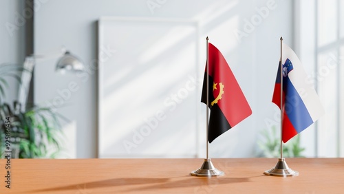 FLAGS OF ANGOLA AND SLOVENIA  ON TABLE photo