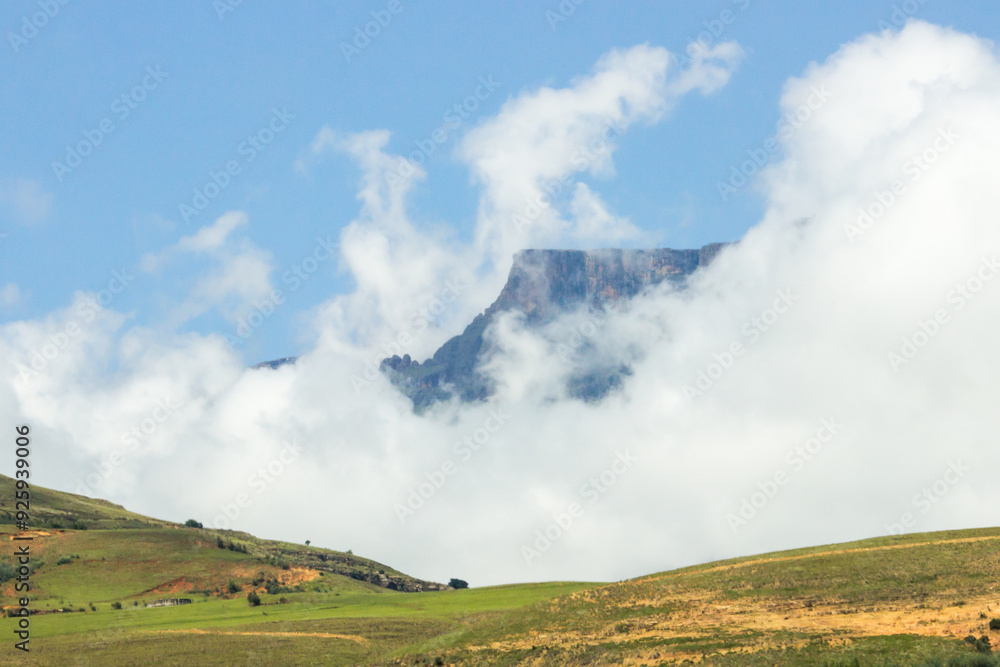 Morning mist retreating, revealing the high cliffs of the Drakensberg mountains, in the Royal Natal National Park of South Africa. Morning mist retreating, revealing the high cliffs of the Drakensberg mountains, in the Royal Natal National Park of South Africa.