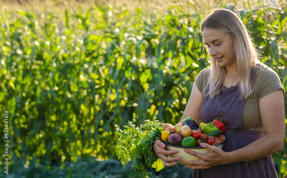 female farmer holding a large plate with various fresh farm vegetables. Autumn harvest