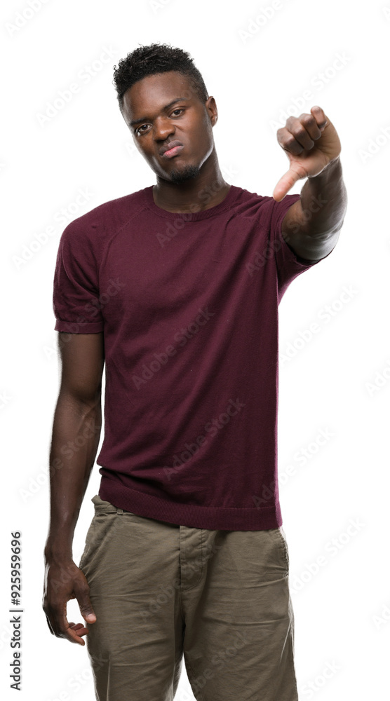 Young african american man with angry face, negative sign showing dislike with thumbs down, rejection concept Young african american man with angry face, negative sign showing dislike with thumbs down, rejection concept