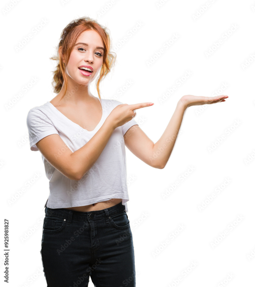 Young beautiful woman over isolated background amazed and smiling to the camera while presenting with hand and pointing with finger. Young beautiful woman over isolated background amazed and smiling to the camera while presenting with hand and pointing with finger.