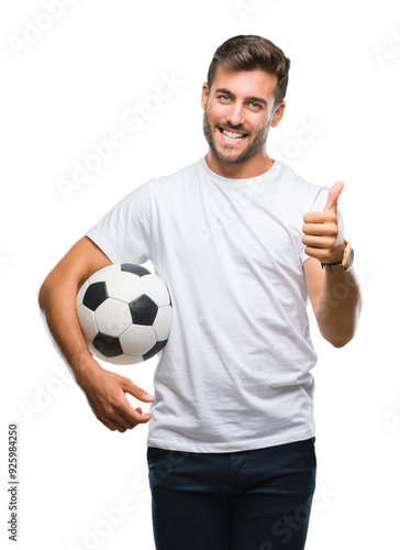 Young handsome man holding soccer football ball over isolated background happy with big smile doing ok sign, thumb up with fingers, excellent sign