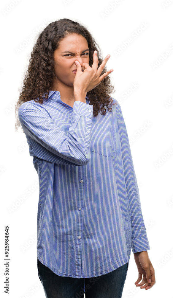 Young hispanic business woman smelling something stinky and disgusting, intolerable smell, holding breath with fingers on nose. Bad smells concept. Young hispanic business woman smelling something stinky and disgusting, intolerable smell, holding breath with fingers on nose. Bad smells concept.