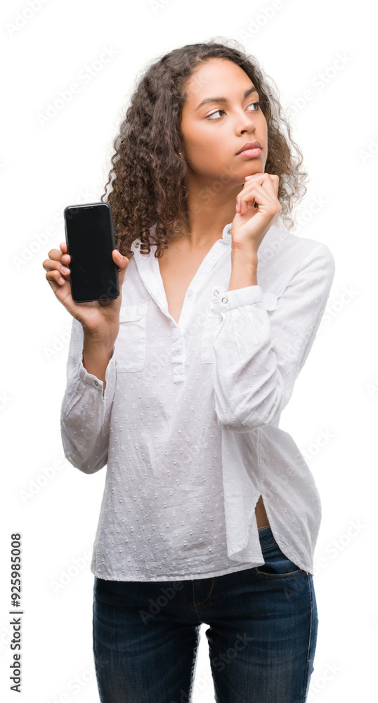 Young hispanic woman using smartphone serious face thinking about question, very confused idea Young hispanic woman using smartphone serious face thinking about question, very confused idea