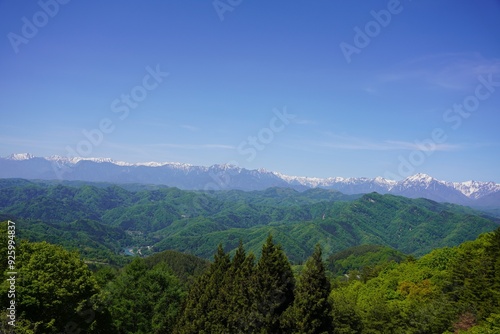 信州　大岡　新緑の里山と残雪の北アルプス