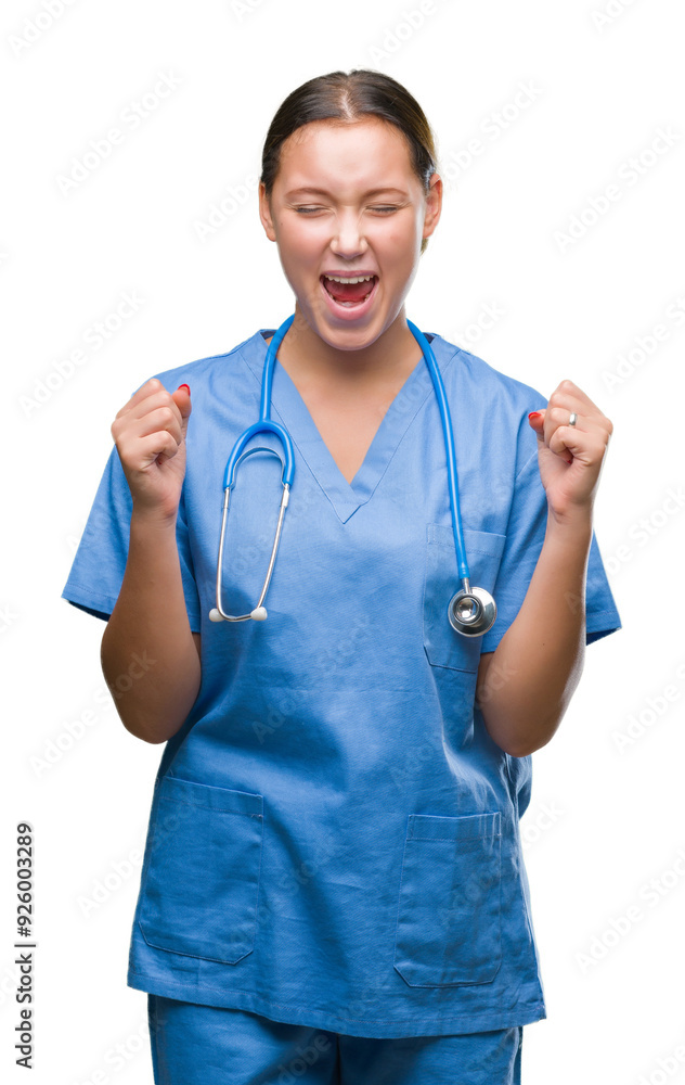 Young caucasian doctor woman wearing medical uniform over isolated background excited for success with arms raised celebrating victory smiling. Winner concept. Young caucasian doctor woman wearing medical uniform over isolated background excited for success with arms raised celebrating victory smiling. Winner concept.