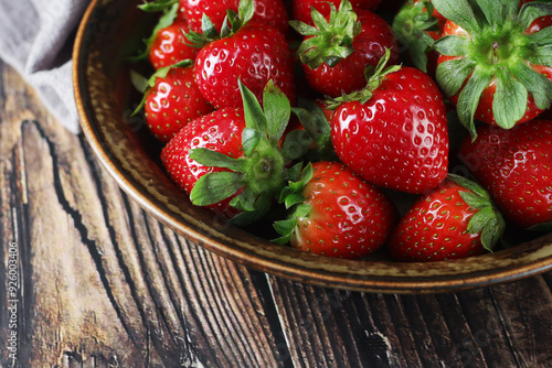 A bowl with ripe bright strawberry in rustic style