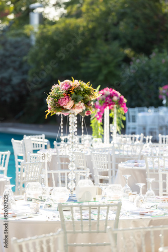 Obraz na płótnie Outdoor wedding reception with round tables, white linens, and tall floral centerpieces w salonie