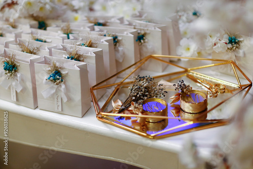 Obraz na płótnie Elegant wedding favor boxes with gold accents and dried flowers, displayed on a geometric glass tray w salonie