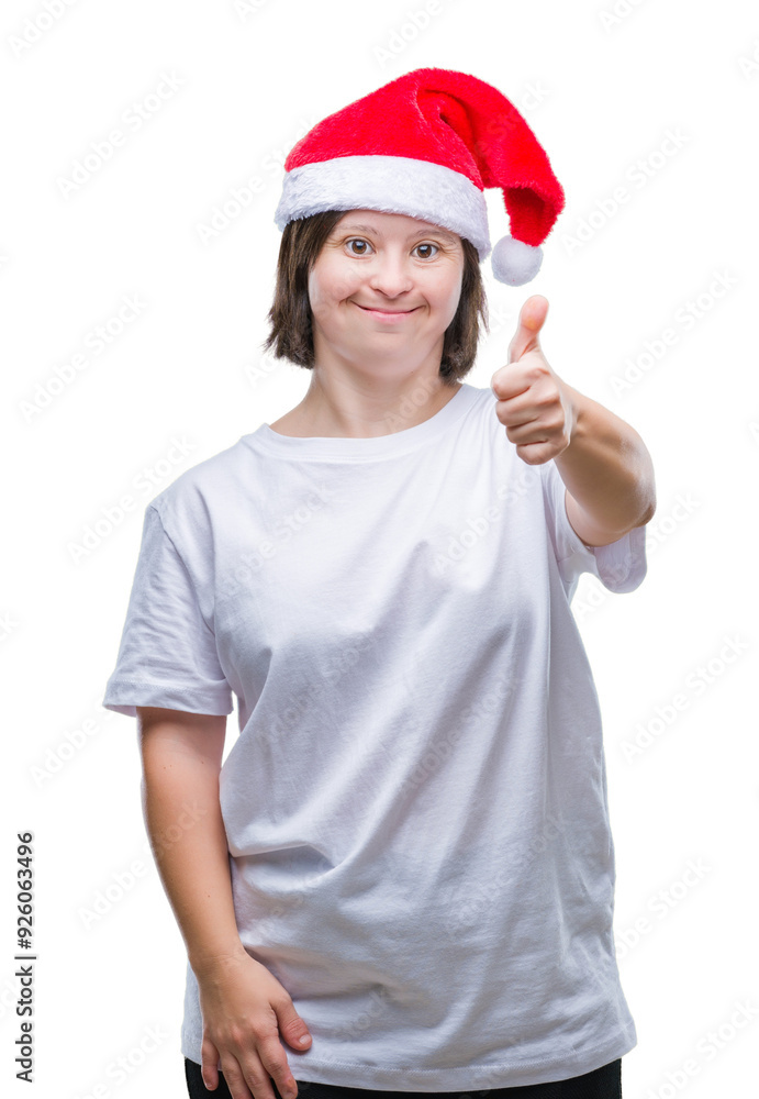 Young adult woman with down syndrome wearing christmas hat over isolated background doing happy thumbs up gesture with hand. Approving expression looking at the camera with showing success. Young adult woman with down syndrome wearing christmas hat over isolated background doing happy thumbs up gesture with hand. Approving expression looking at the camera with showing success.