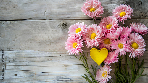 bouket of pink flowers and yellow heart on wooden background ,Purple, pink laid out in the shape of a heart on an old wooden background ,Background, texture, idea, concept ,Beautiful flowers andheart
 photo