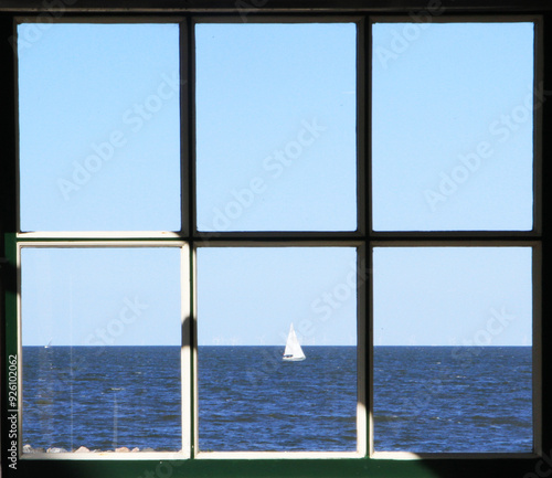 Vista del mar y de un barco a través de una ventana photo