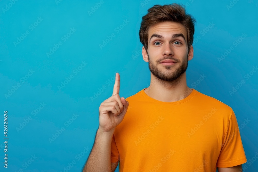 Photo of attractive dreamy man dressed orange shirt looking showing finger empty space isolated blue color background with generative ai Photo of attractive dreamy man dressed orange shirt looking showing finger empty space isolated blue color background with generative ai