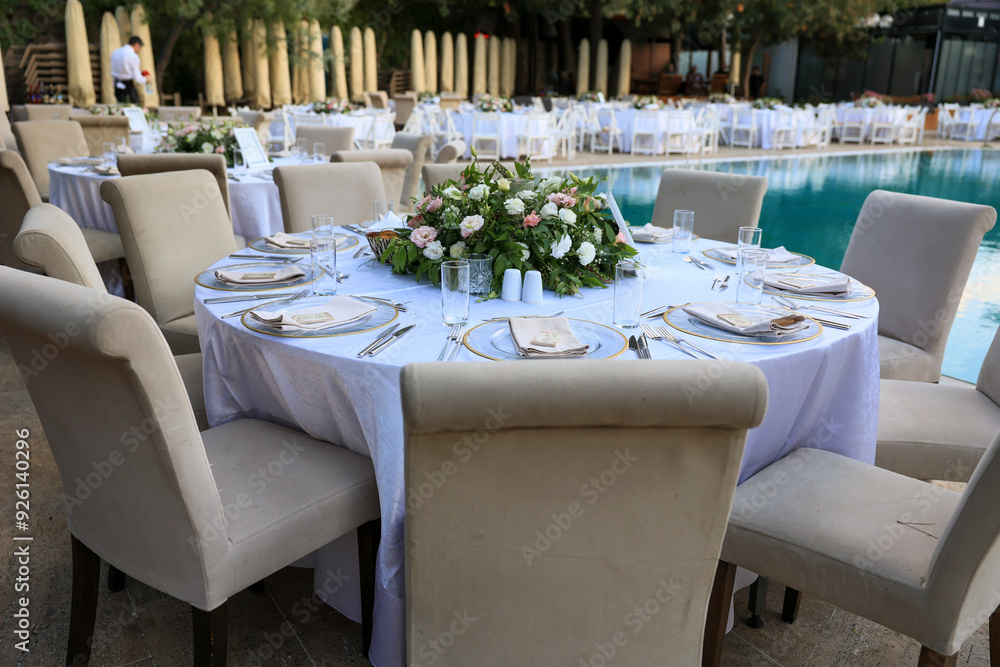 Elegant Poolside Wedding Reception with Round Tables and White Chairs