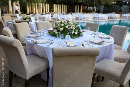 Obraz na płótnie Elegant Poolside Wedding Reception with Round Tables and White Chairs w salonie