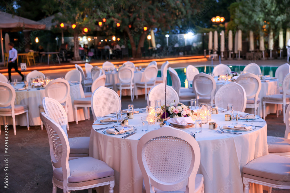 Elegant Poolside Wedding Reception with Round Tables and White Chairs