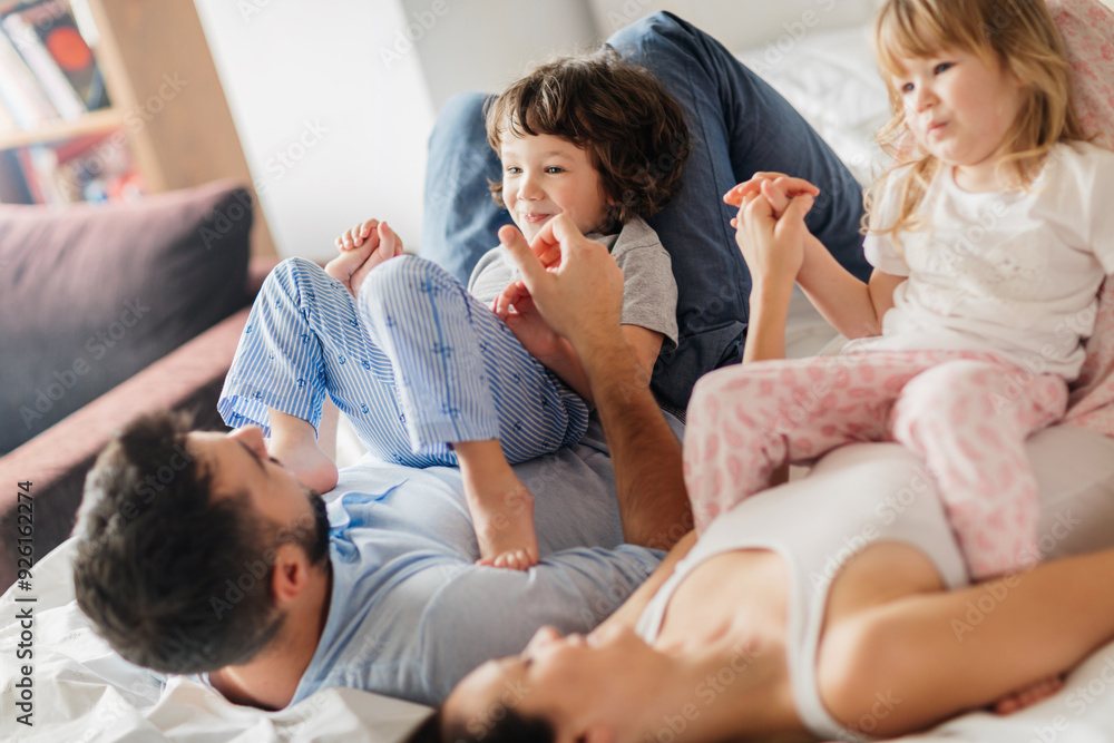 Happy family playing and laughing together on bed in the morning Happy family playing and laughing together on bed in the morning