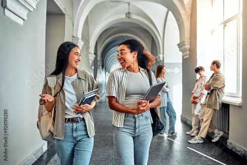 Fotomural Young modern female college students walking down corridor and talking