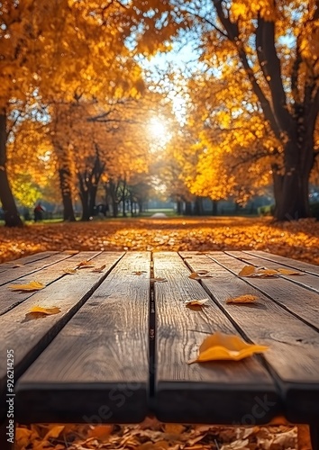 Sunlit wooden table with a vibrant autumn park background, ideal for creating warm, seasonal presentations. photo