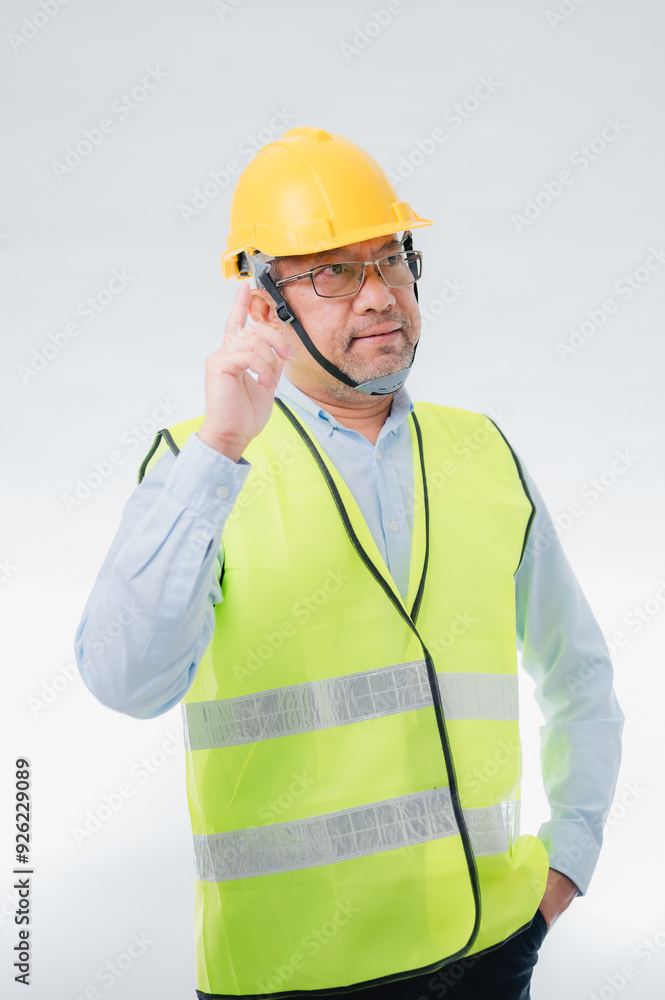 A engineer man in a yellow vest and a yellow helmet is standing in front of a white background. He is wearing glasses and has his hands up in the air A engineer man in a yellow vest and a yellow helmet is standing in front of a white background. He is wearing glasses and has his hands up in the air