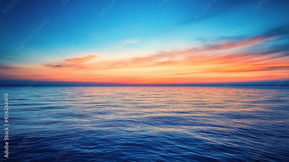 Obraz premium Serene Sunset over Tranquil Sea: A breathtaking view of a fiery sunset over the vast, tranquil ocean, creating a mesmerizing interplay of colors and emotions.