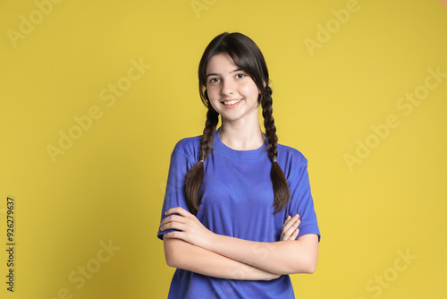 Portrait of smiling teenage girl on yellow background