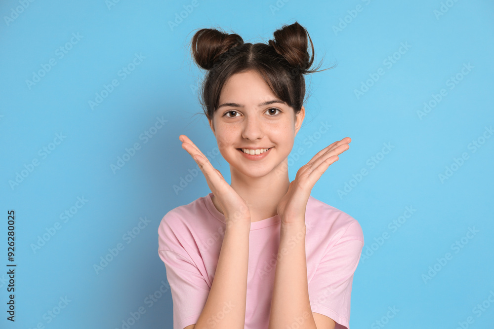 Portrait of smiling teenage girl on light blue background Portrait of smiling teenage girl on light blue background