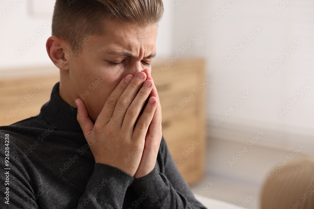 Young man suffering from sinusitis at home, space for text Young man suffering from sinusitis at home, space for text