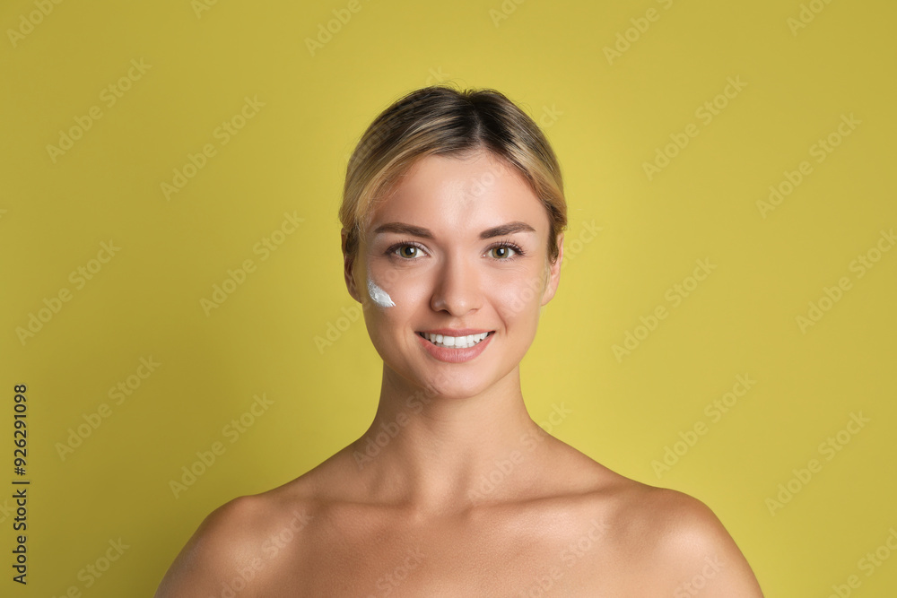 Beautiful woman with cream on her face against olive background Beautiful woman with cream on her face against olive background