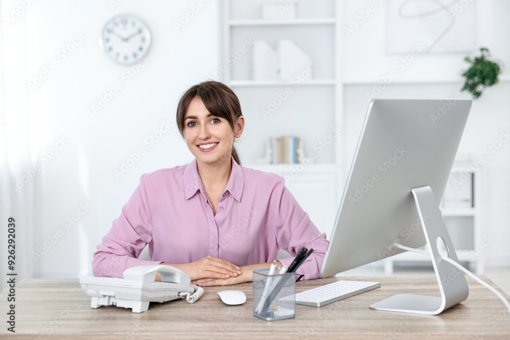 Portrait of receptionist at wooden desk in office Portrait of receptionist at wooden desk in office