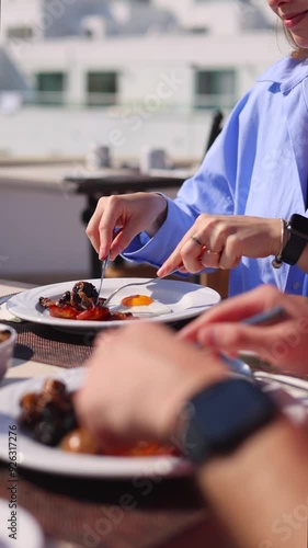 Close up. Couples hands sharing breakfast on a bright day