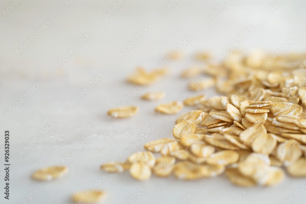 Close-up of raw rolled oats scattered on a light background, emphasizing texture and organic grains for healthy eating and natural food concepts Close-up of raw rolled oats scattered on a light background, emphasizing texture and organic grains for healthy eating and natural food concepts