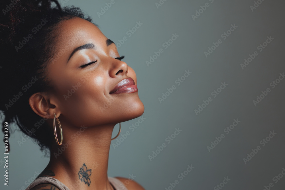 A close up of a tattooed black woman's face with her eyes closed