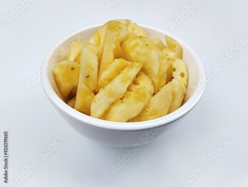 Fresh pineapple pieces in bowl isolated on white background 