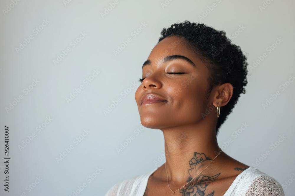 A close up of a tattooed black woman's face with her eyes closed A close up of a tattooed black woman's face with her eyes closed