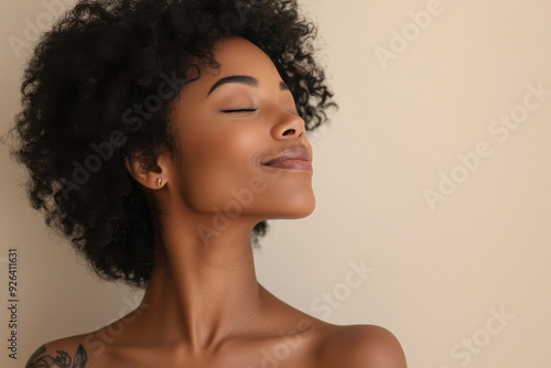 A close up of a tattooed black woman's face with her eyes closed