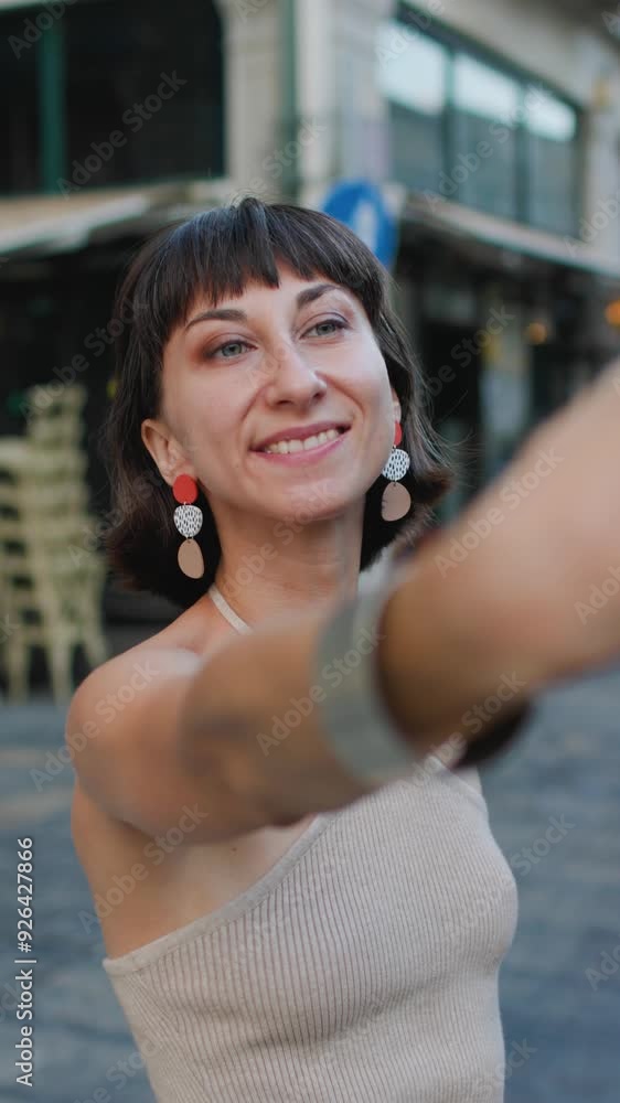 vertical shot. A young woman takes a selfie using a smartphone camera. Young beautiful woman smiling happy walking on city streets on a sunny day of summer taking a selfie photo using smartphone
vertical shot. A young woman takes a selfie using a smartphone camera. Young beautiful woman smiling happy walking on city streets on a sunny day of summer taking a selfie photo using smartphone
