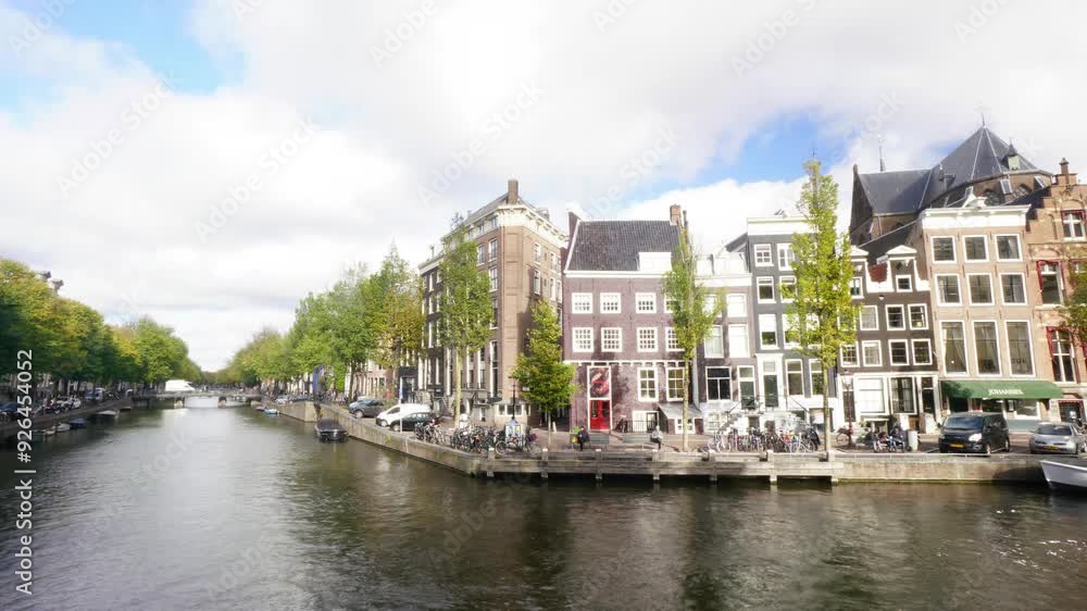 A row of colorful buildings line a canal in a city. The buildings are tall and narrow, with many windows. The canal is filled with boats of various sizes, including a yellow one. The scene is lively A row of colorful buildings line a canal in a city. The buildings are tall and narrow, with many windows. The canal is filled with boats of various sizes, including a yellow one. The scene is lively